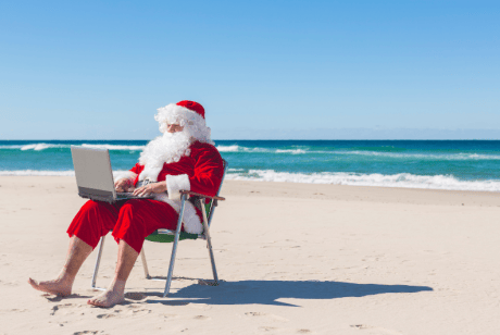Santa Clause working while vacationing at the beach