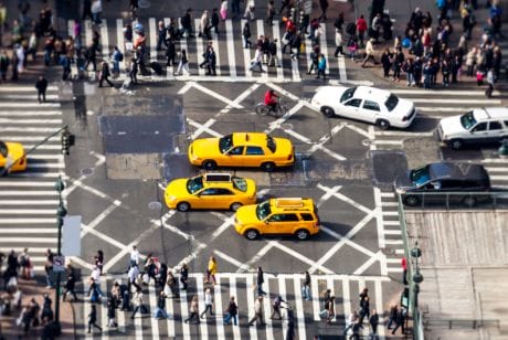 Yellow cabs and people crossing zebra crossing